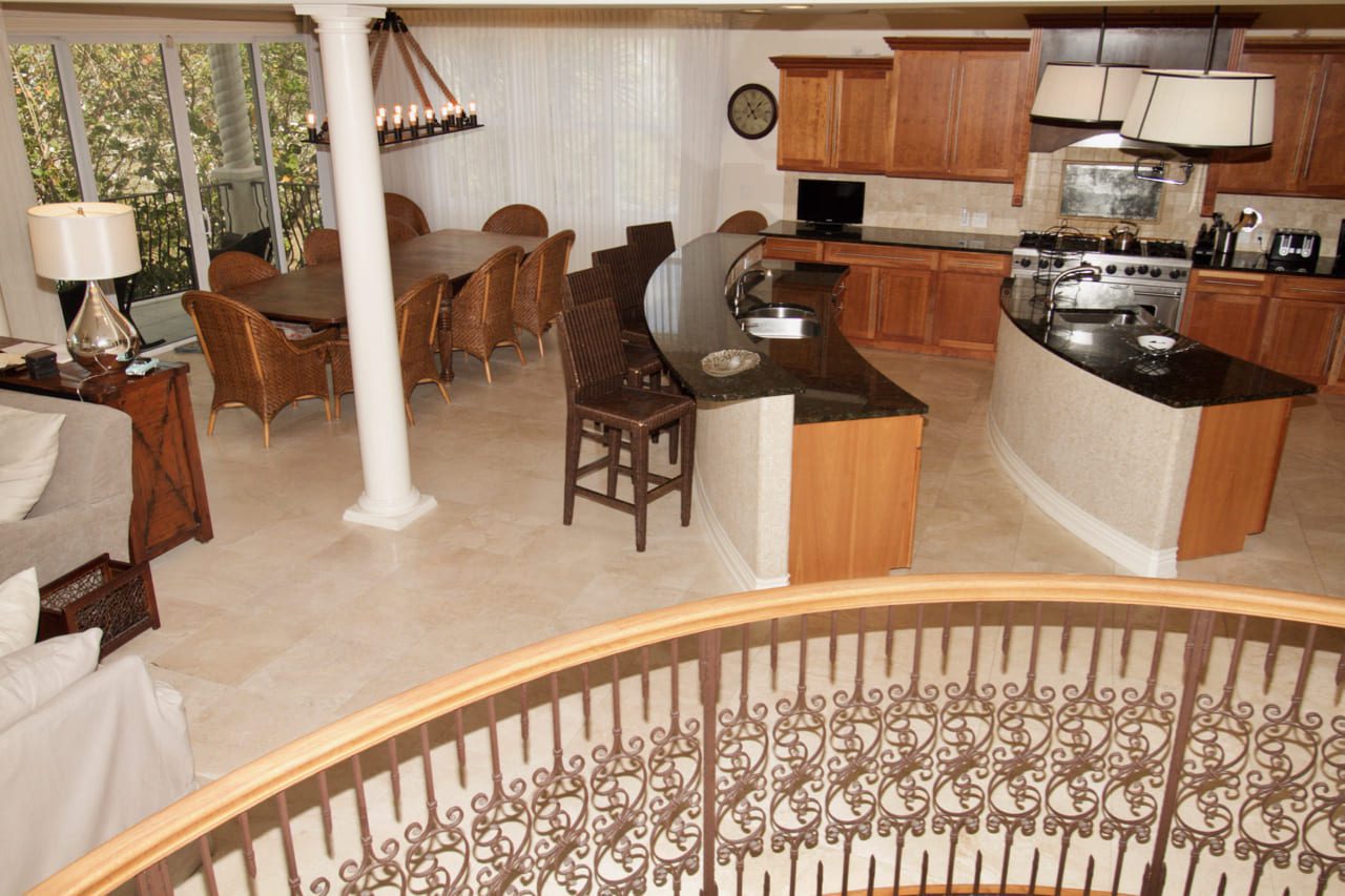 A kitchen with a table and chairs, a counter top and a dining room.