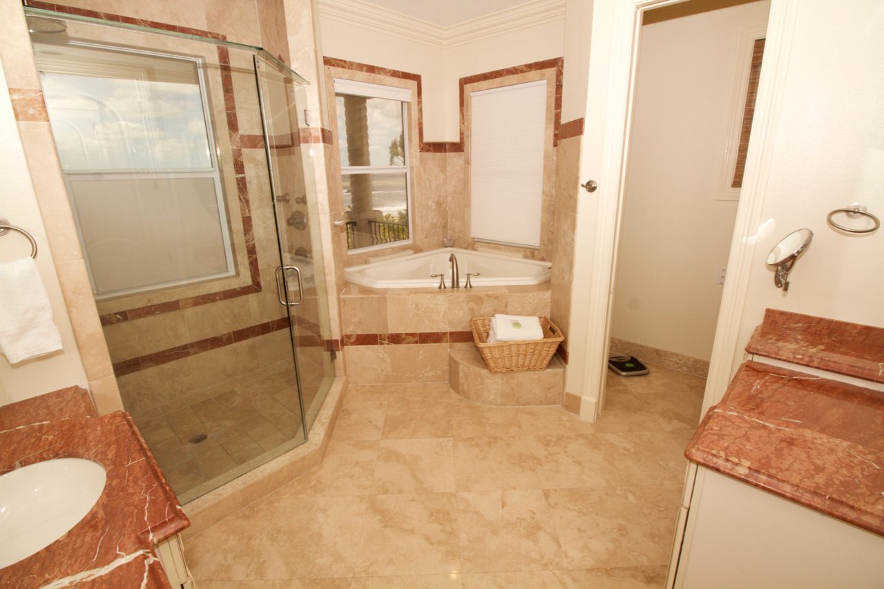 A bathroom with a large shower and a tub.